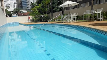 Alberca al aire libre y camastros