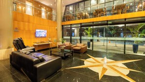 A lobby with a massage chair, seating area, and a large star-shaped floor design.