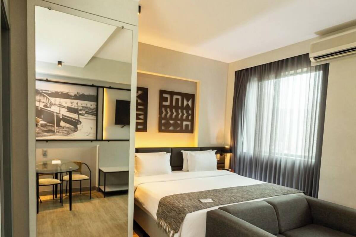 Une chambre d’hôtel moderne équipée d’un lit, d’un canapé, d’un bureau et d’une chaise.