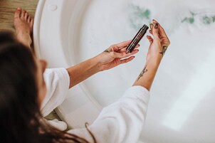 Una persona sosteniendo una botella en una bañera.