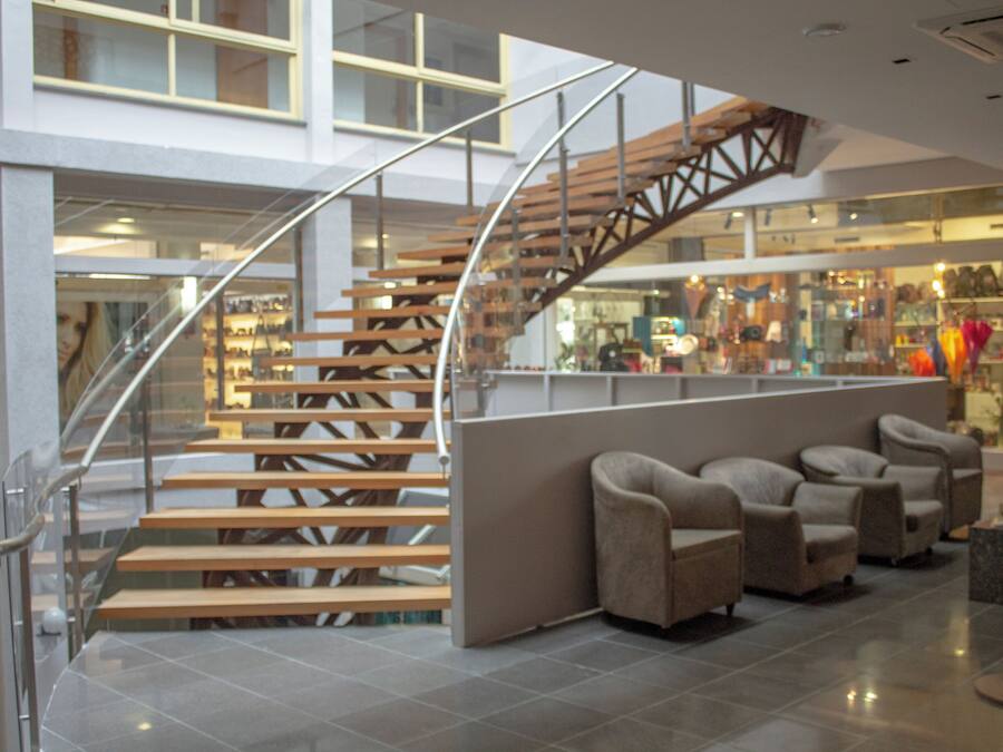 A modern interior with a spiral staircase, seating area, and retail space.