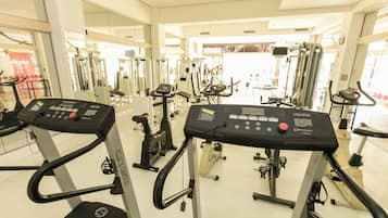Una sala de gimnàstica amb cintes de córrer, el·líptiques i aparells de musculació.