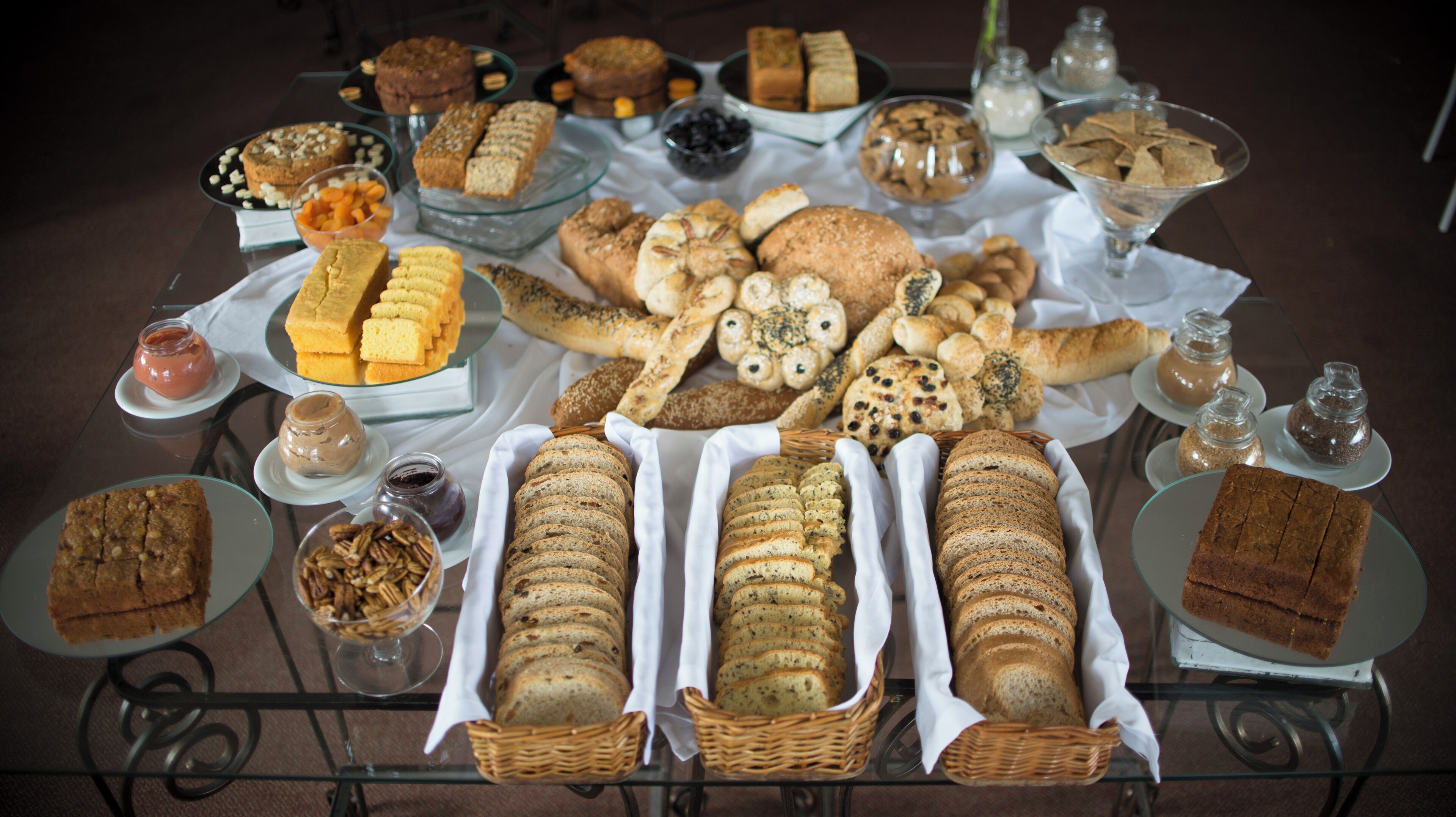 Una variedad de panes y pasteles expuestos sobre una mesa.