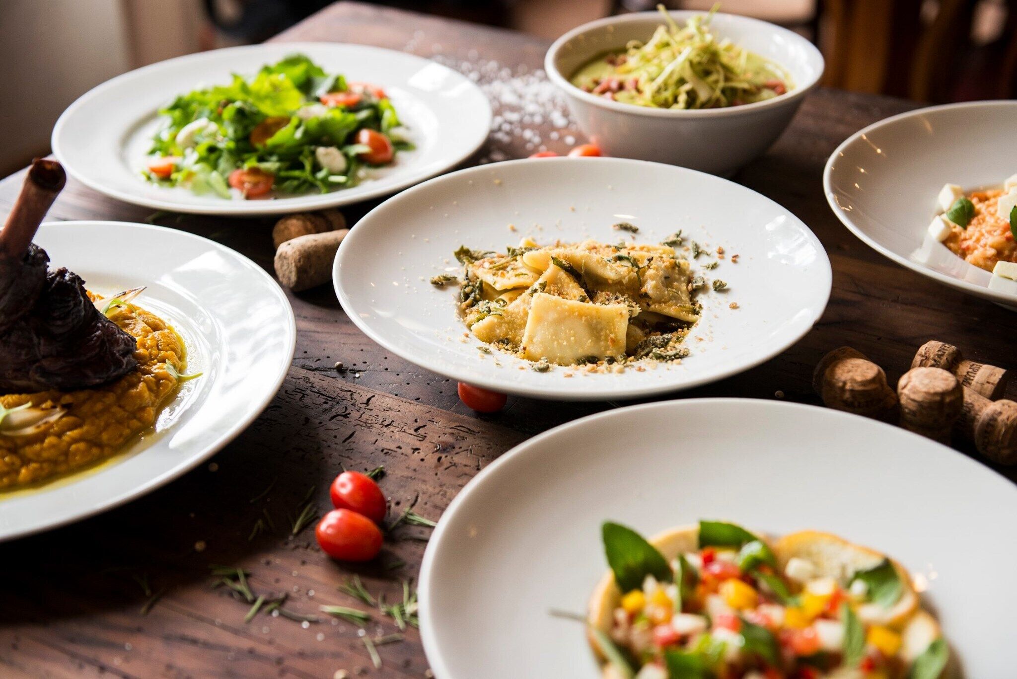 A table with various dishes including pasta, a salad, and a meat dish.