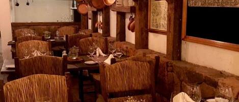 Un comedor rústico con muebles de madera y ollas colgantes.