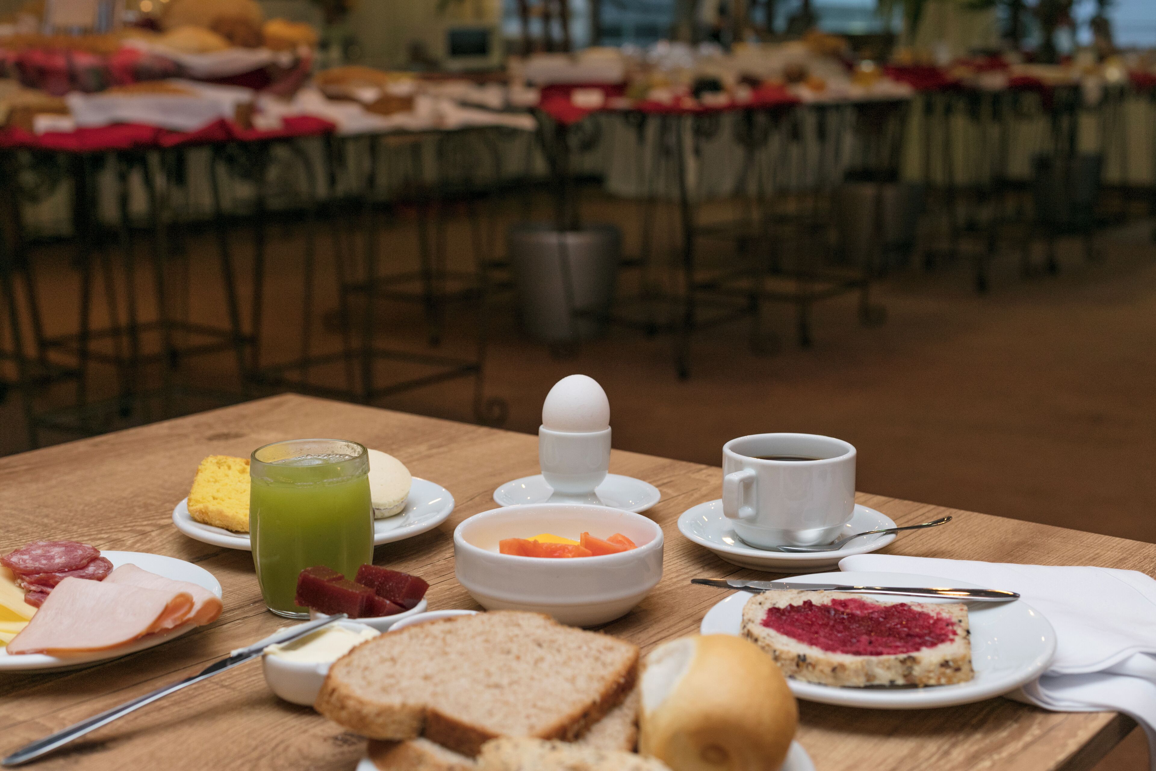 A breakfast table with various food items and a cup of coffee.