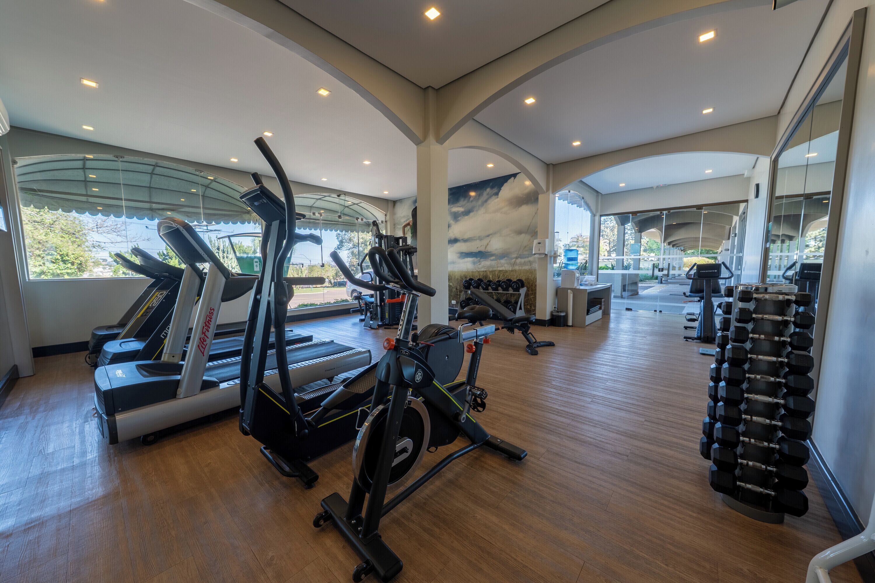 A gym with treadmills, elliptical machines, and free weights.