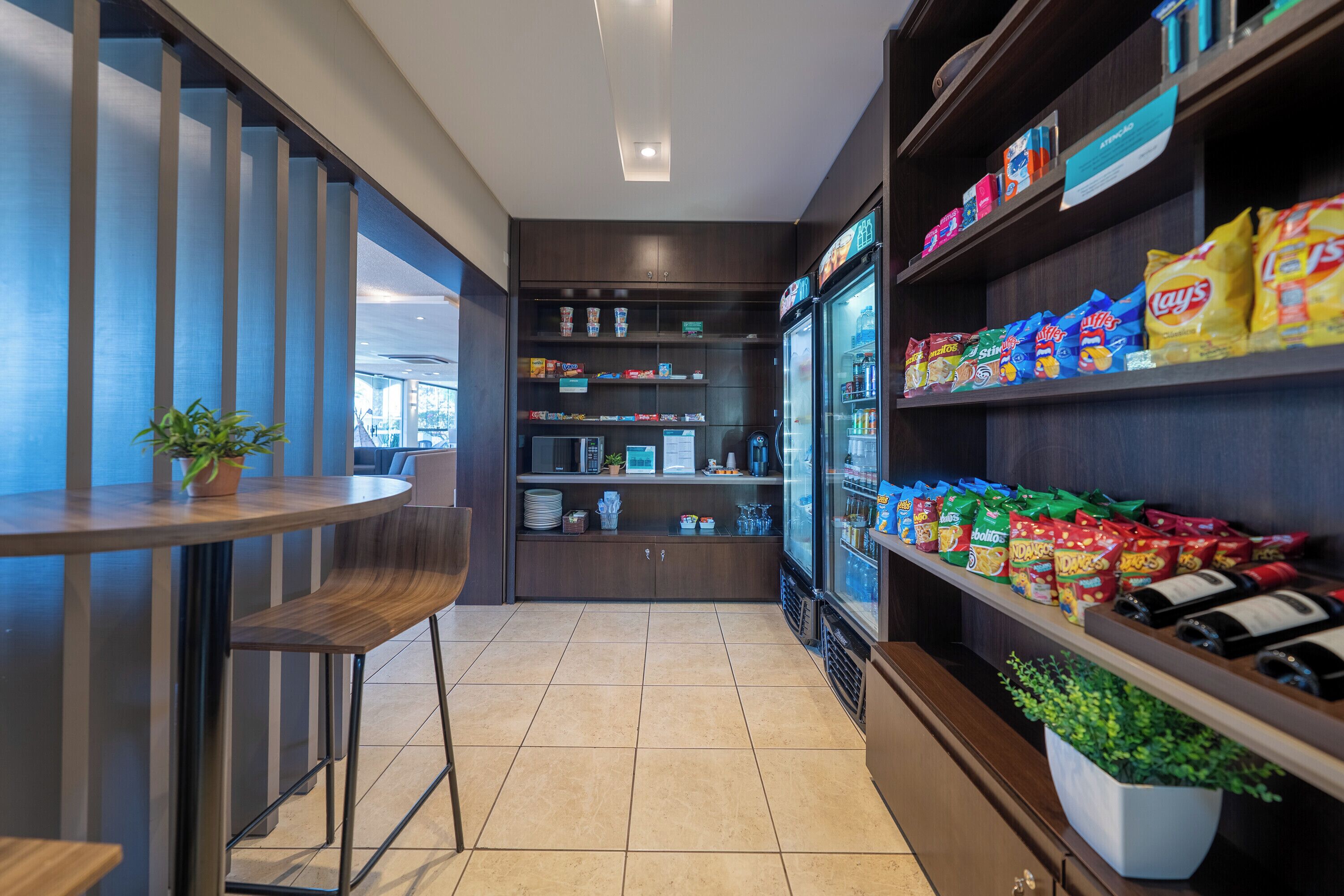A modern interior with a bar area, seating, and snack shelves.