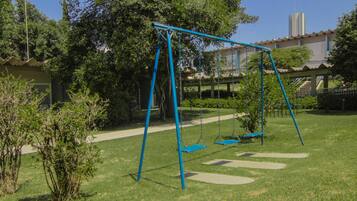 Relax in a serene park-like setting with a charming swing set amidst lush greenery.