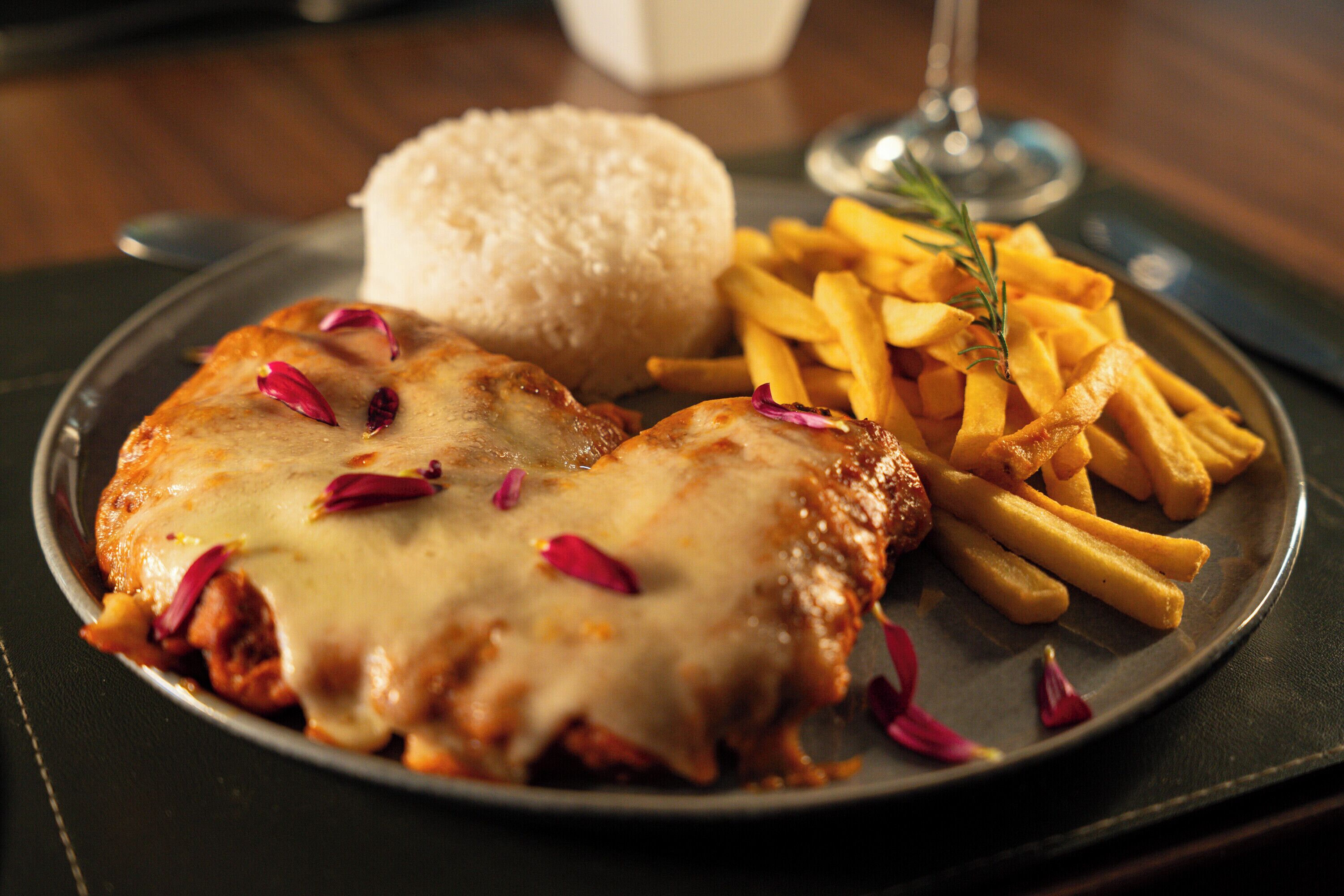 Une assiette composée de poulet, de frites et de riz.