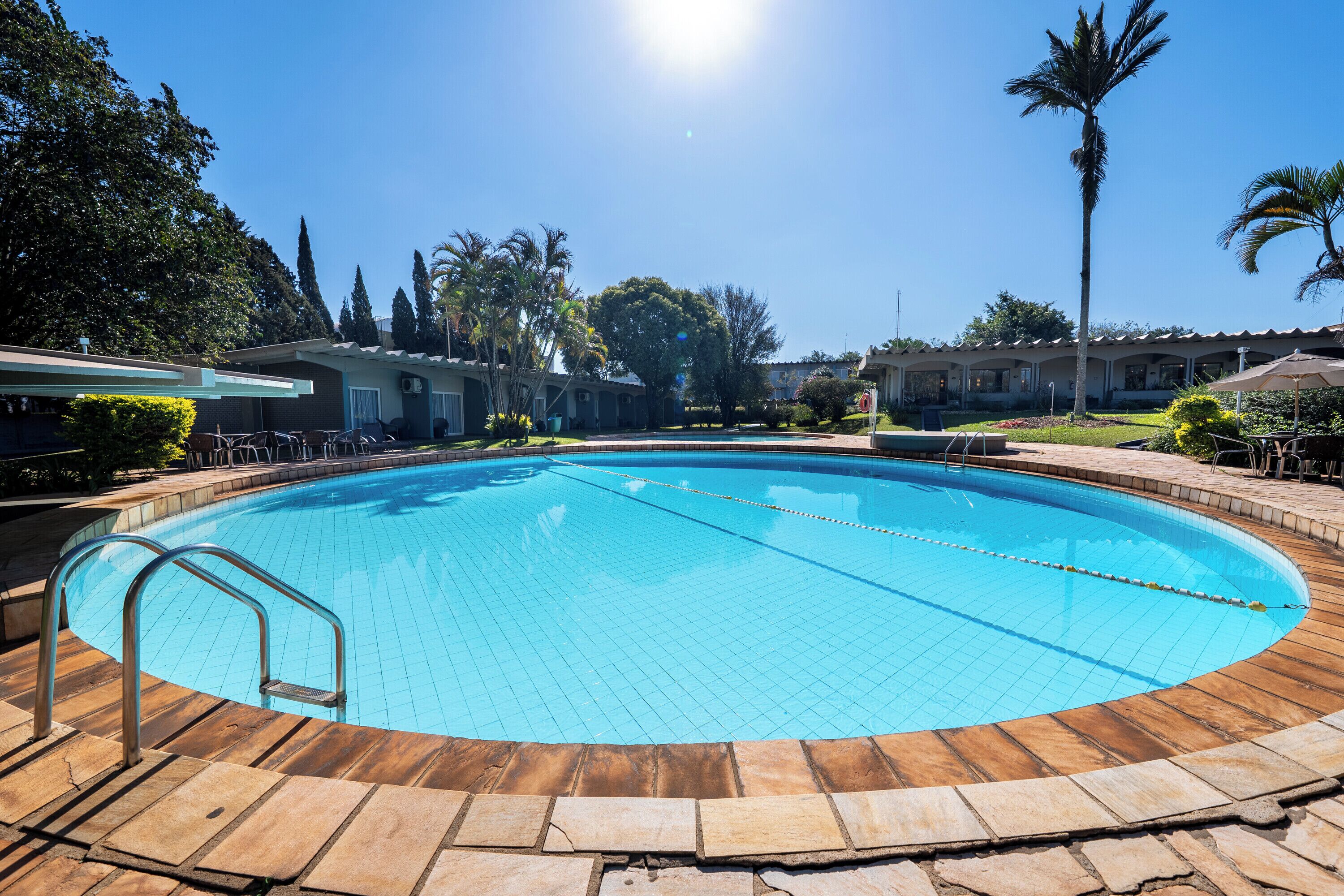 A swimming pool with a wooden deck and a metal ladder.