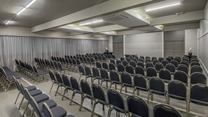 A conference room with rows of chairs, a podium, and curtains. - Hotel Deville Express Cascavel (Cascavel)
