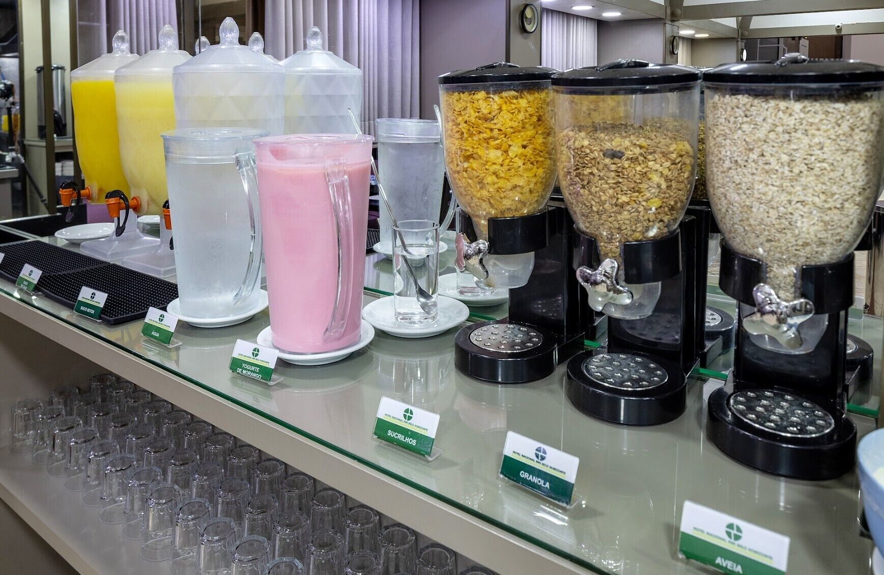 A self-serve station with various food items and drinks, including yogurt, granola, and smoothies.