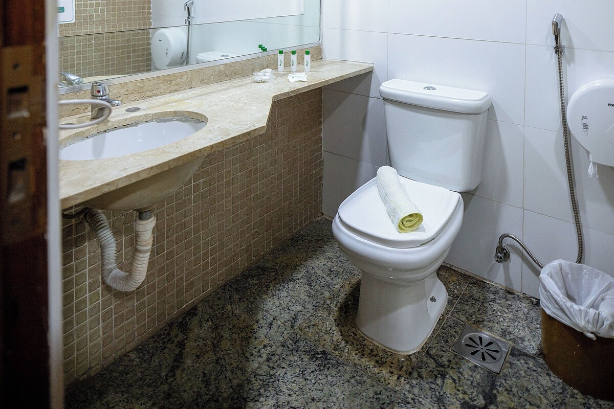 A bathroom with two sinks, a toilet, a shower, and a mirror.