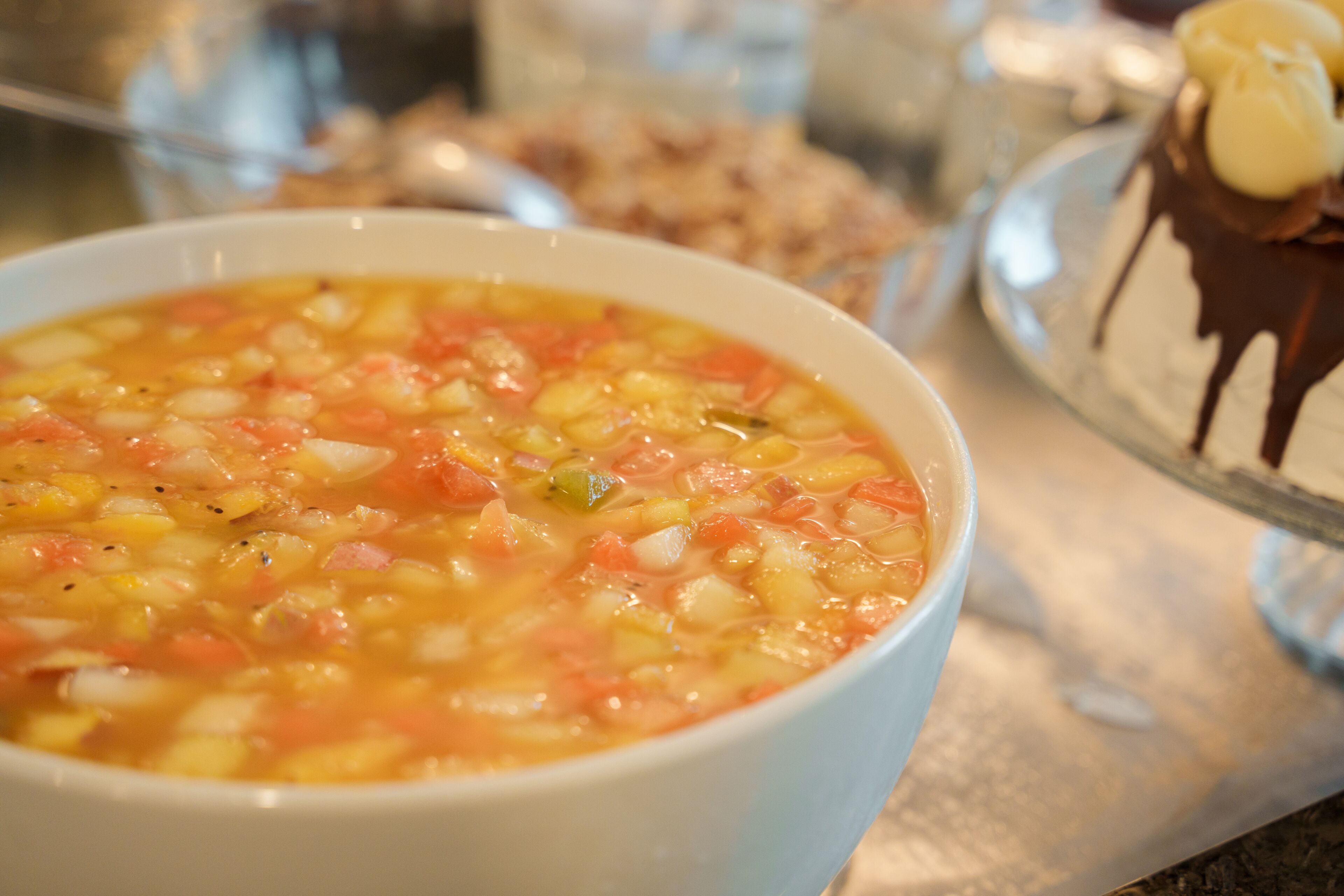A bowl of soup with visible ingredients like corn and tomatoes.