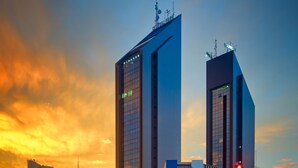 A modern building with a unique architectural design, featuring two tall structures with reflective glass facades. - Central Park Hotel by Bourbon (Cascavel)