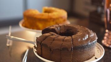Un pastel de chocolate con cobertura de chocolate sobre un plato blanco.