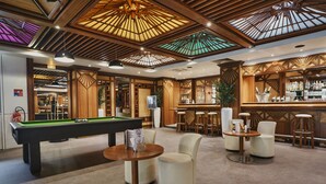 Un espace bar équipé d’une table de billard, de tabourets de bar et d’un comptoir.