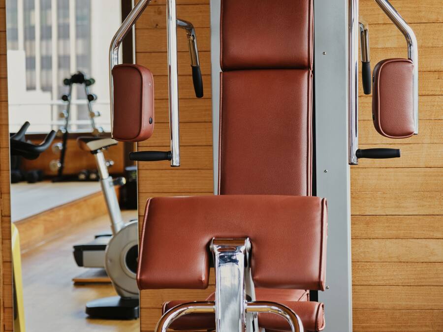 A gym with a stationary bike, a rowing machine, and a weight bench.
