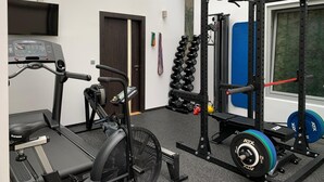 Un gimnasio con equipo de cardio, máquinas de pesas y un amplio ventanal.