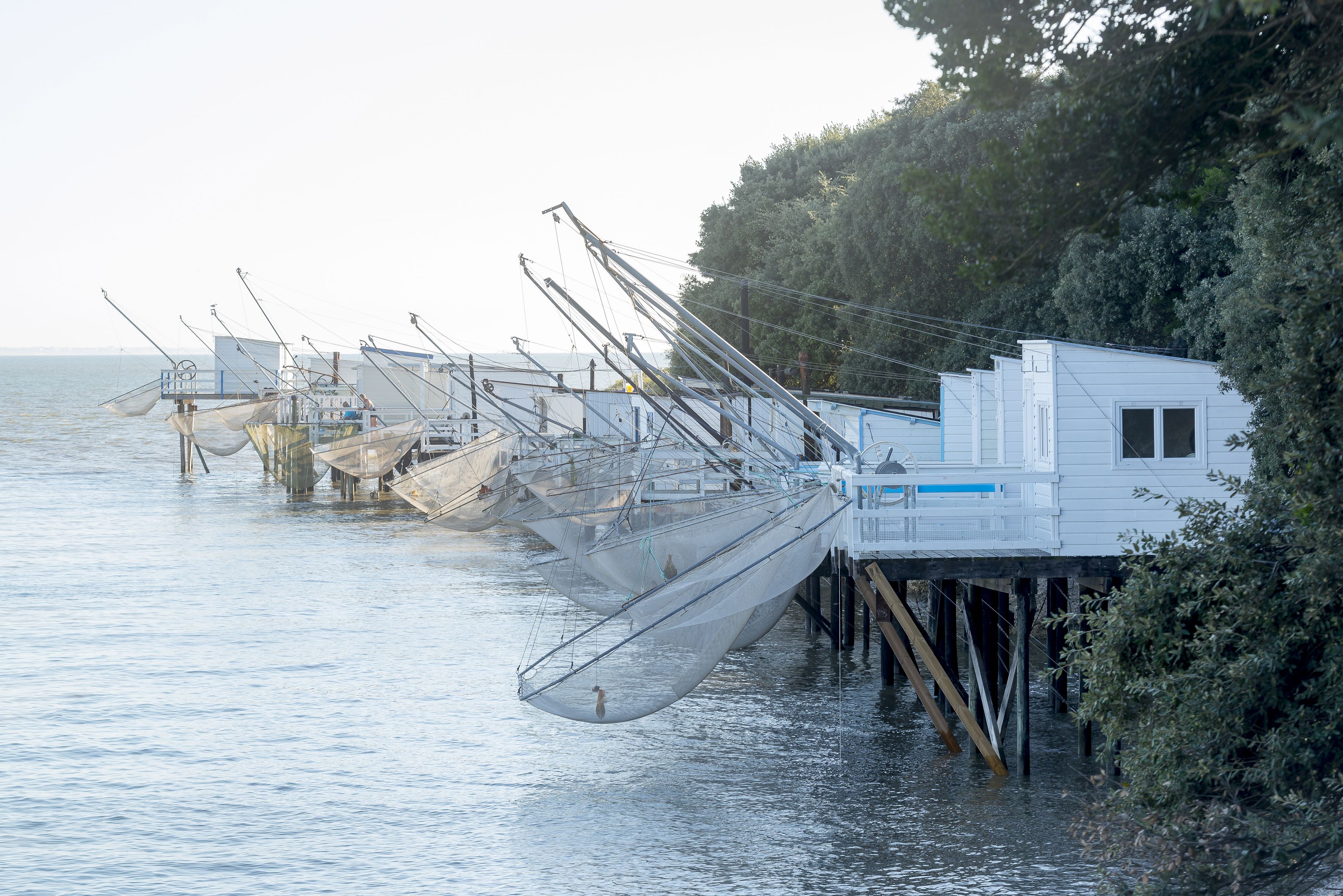 Un quai où sont amarrés plusieurs bateaux de pêche et un petit bâtiment blanc doté d’une fenêtre.