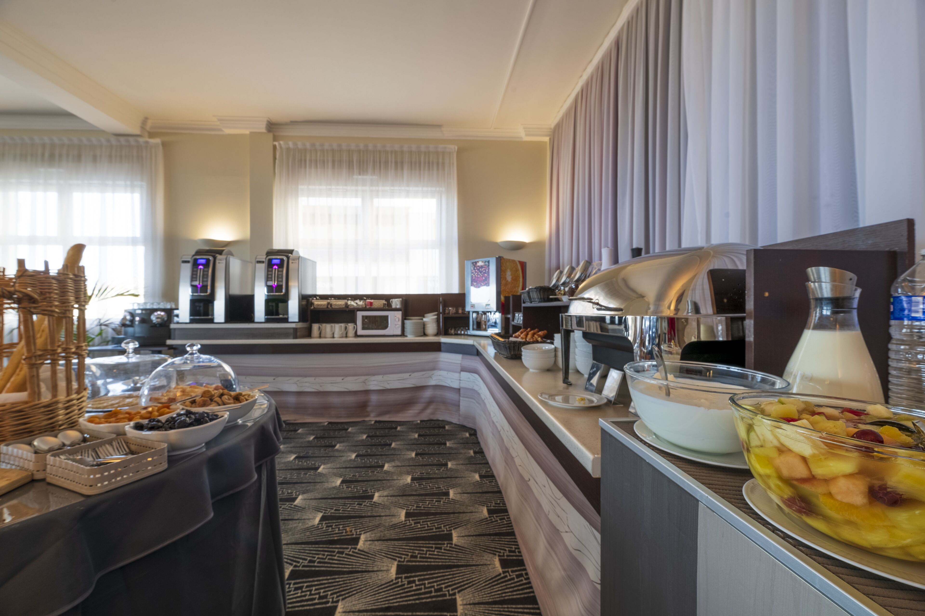 Un espace buffet proposant divers plats, un coin café et un four à micro-ondes.