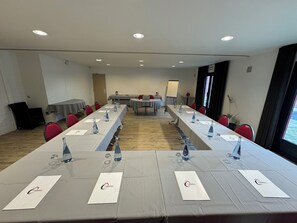 A conference room with long tables, chairs, and a whiteboard. - The Originals City, Hôtel Le Gayant (Douai)
