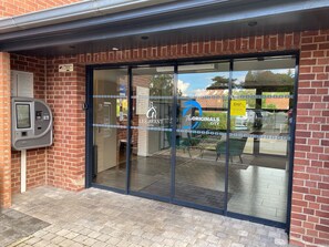 A hotel entrance with a glass door, a parking meter, and a sign for The Originals City.