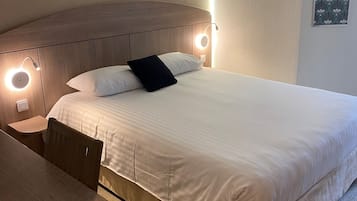Une chambre d’hôtel avec un lit, une table de chevet et une chaise.