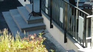 An outdoor café with white umbrellas, outdoor seating, and a staircase leading to the entrance. - Le Parc des Fées (La Bourboule)