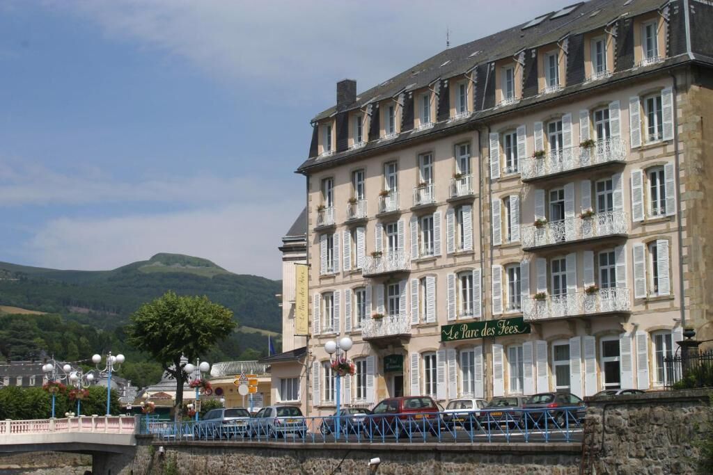 A historic building with multiple balconies and a sign reading "Le Parc des Feux".
