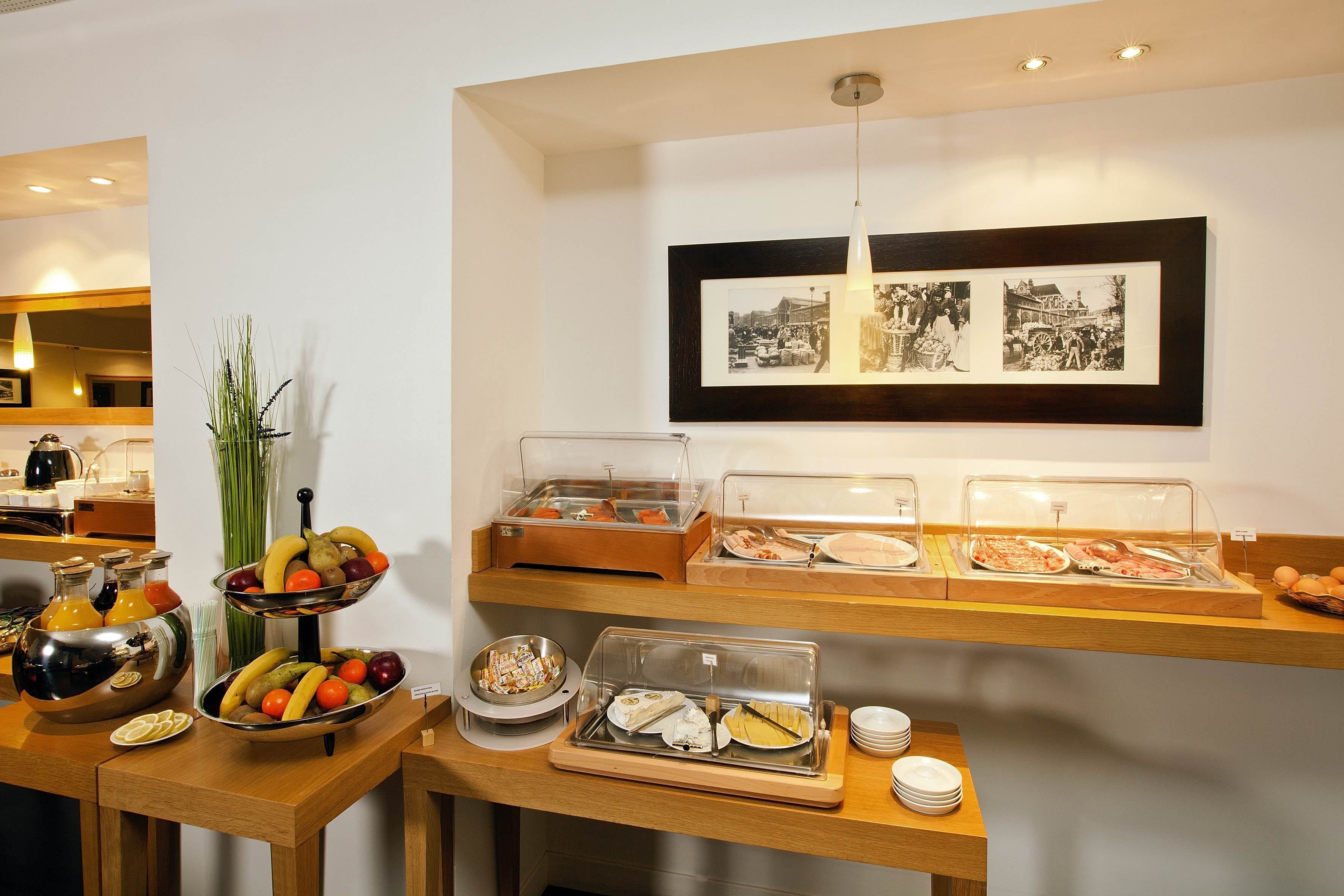 Un espace buffet proposant divers plats et un mur orné de photographies encadrées.