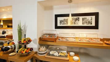 Un espace buffet proposant divers plats et un mur orné de photographies encadrées.