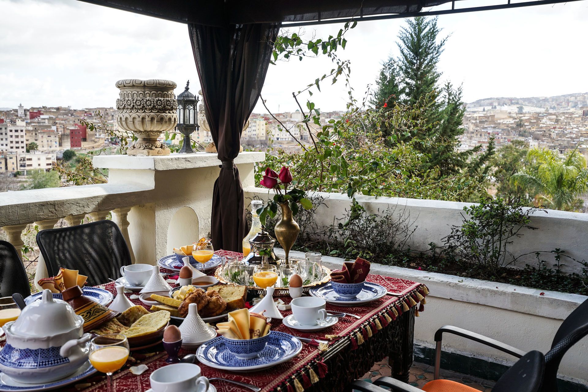 Ein Tisch ist für ein Frühstück gedeckt, mit Blick auf eine Stadtlandschaft.