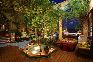 Relax in a serene courtyard surrounded by lush greenery and a tranquil fountain.