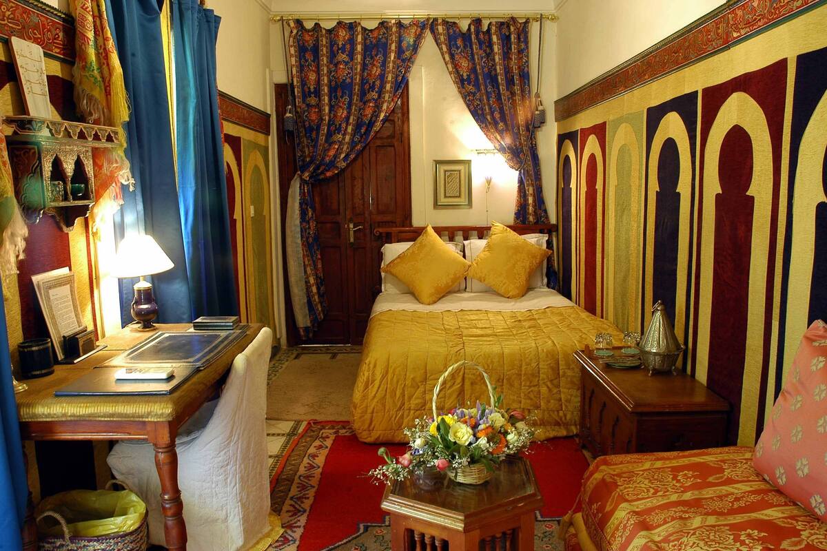 A traditional room with a bed, a desk, and a chair.
