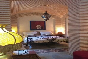Ein Schlafzimmer mit einem Bett, einer Hängelampe und einem Gemälde an der Wand.