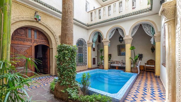 A courtyard with a swimming pool, arches, and traditional Moroccan architecture. - Riad Maison Arabo-Andalouse (Marrakech)
