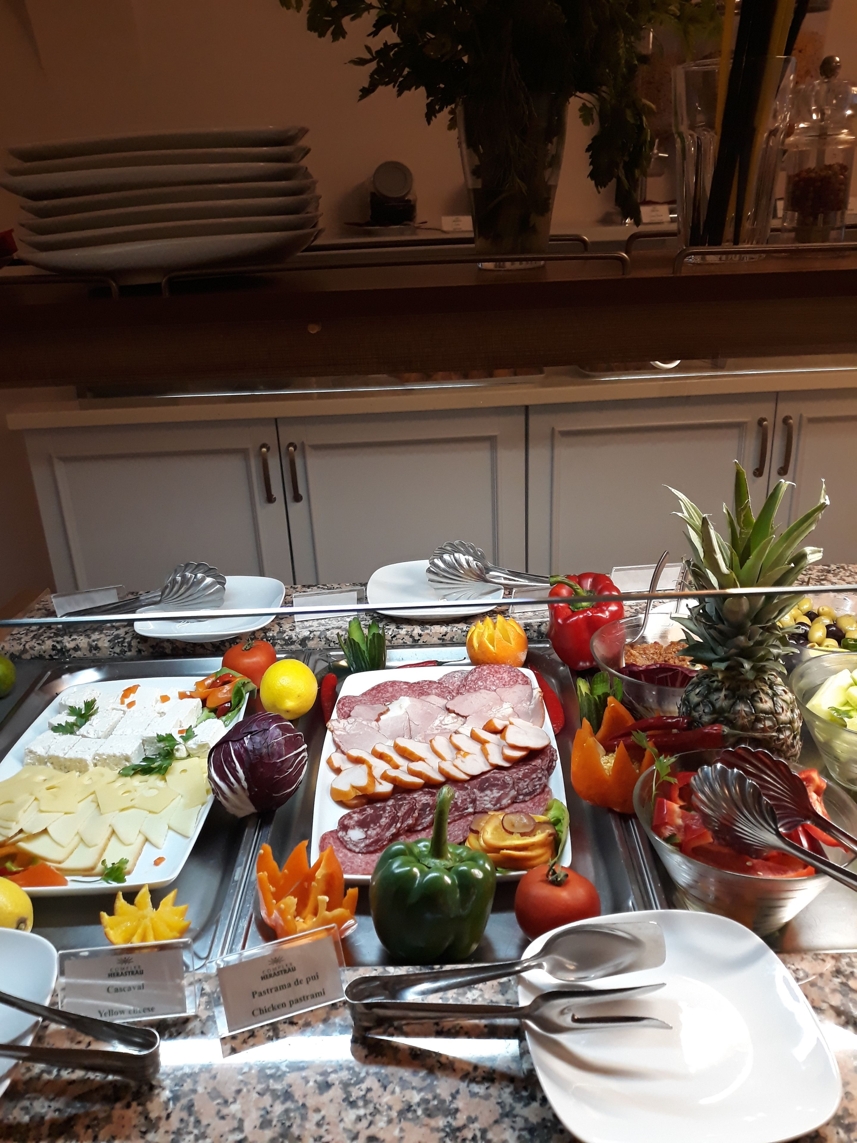 Un bufé con diversos alimentos, incluyendo queso, carnes y verduras.