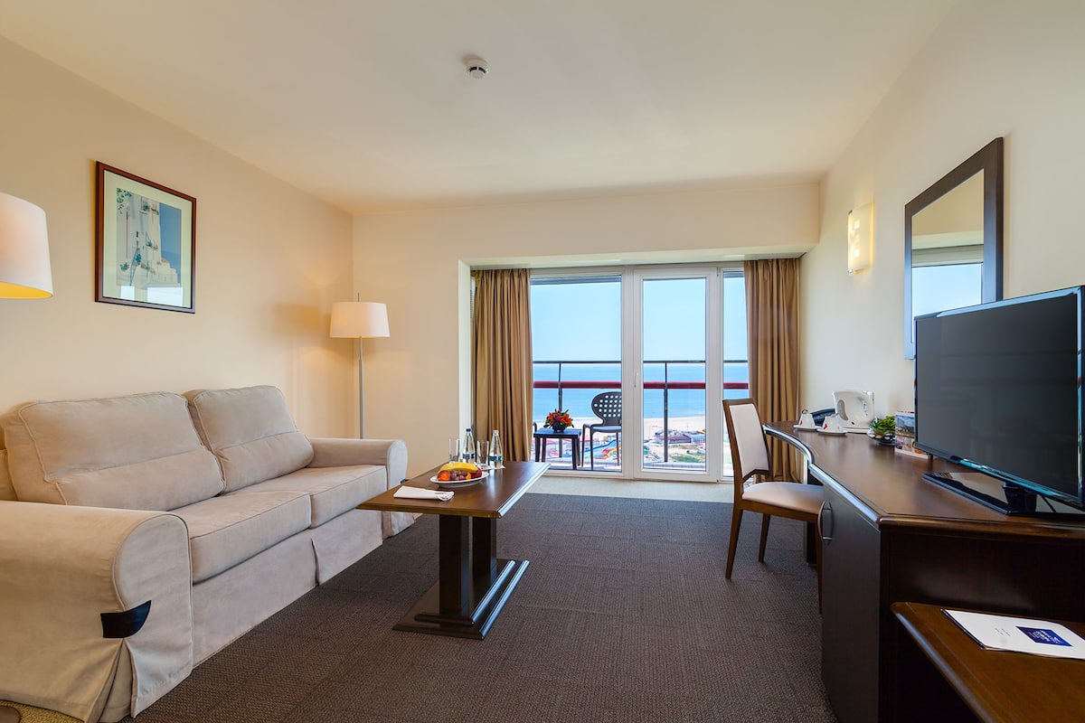Suite junior, 1 cama King size | Área de sala de estar | Televisión de pantalla plana