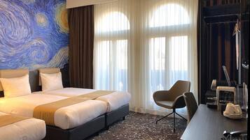 Une chambre d’hôtel avec un grand lit, un bureau avec un téléphone et une chaise.