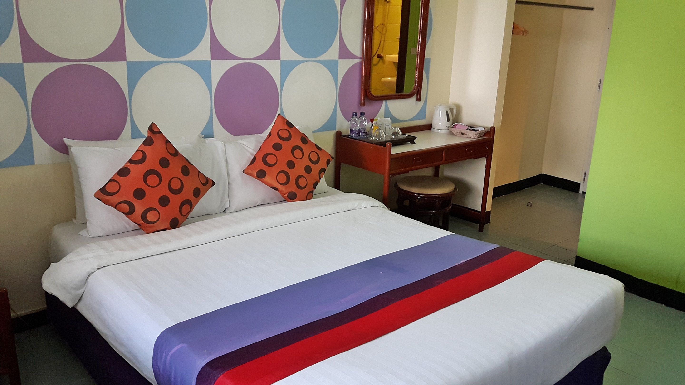 Een hotelkamer met een bed, een bureau en een stoel.