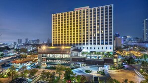 Un hotel moderno de gran altura, con varios pisos y un cartel llamativo en la parte superior.
