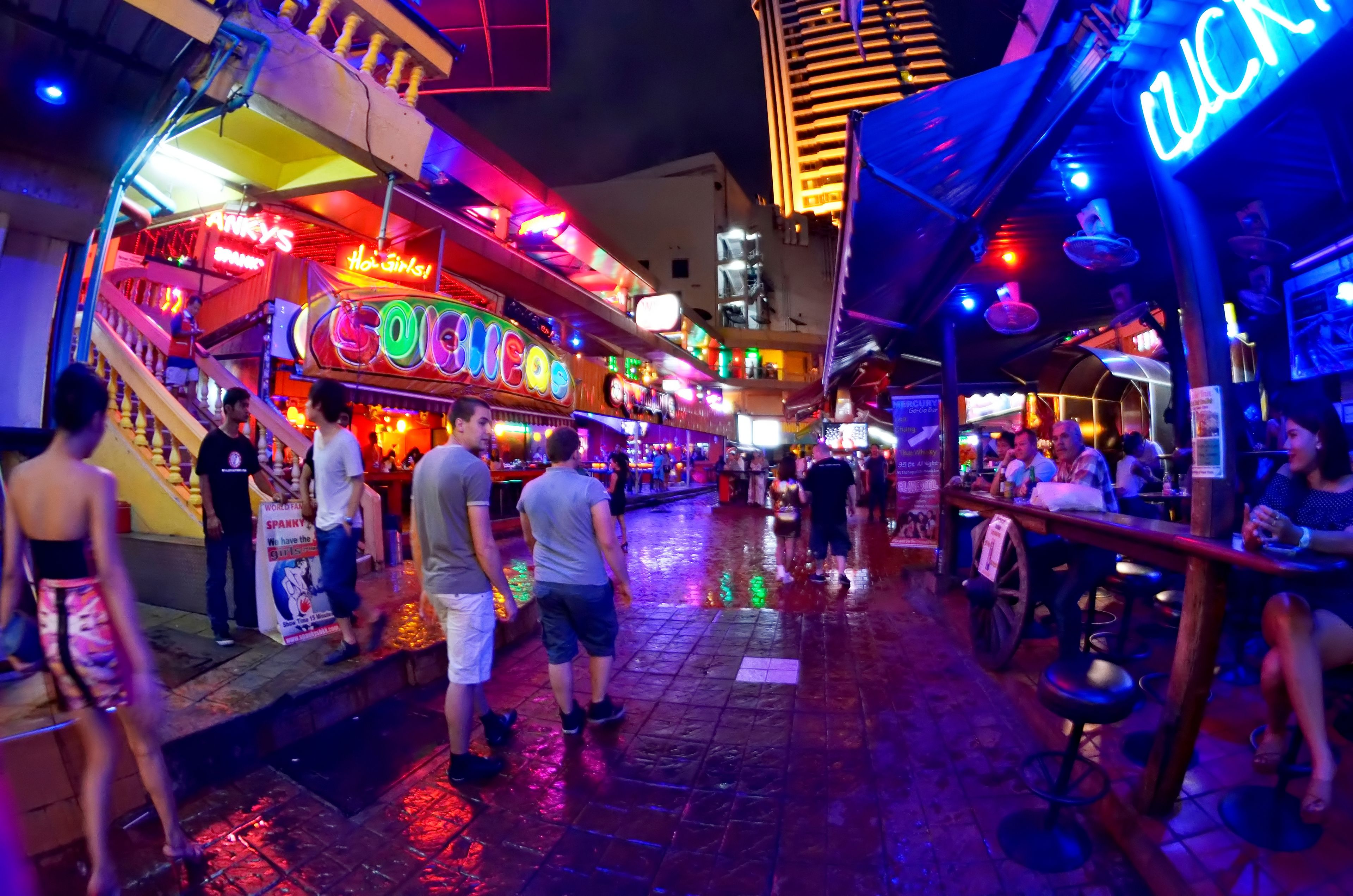 A bustling street scene with neon signs and people walking.