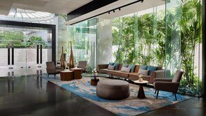 Een modern interieur met een glazen wand, een zithoek en een salontafel.