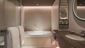 A modern bathroom with a bathtub, a sink, and a mirror.