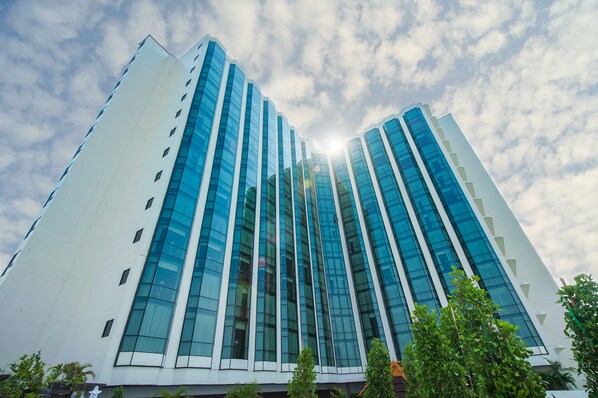 Un moderno edificio de gran altura con fachada de vidrio y exterior blanco.