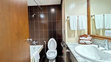 A bathroom with a toilet, sink, and bathtub.