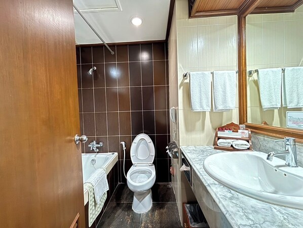 A bathroom with a toilet, sink, and bathtub.