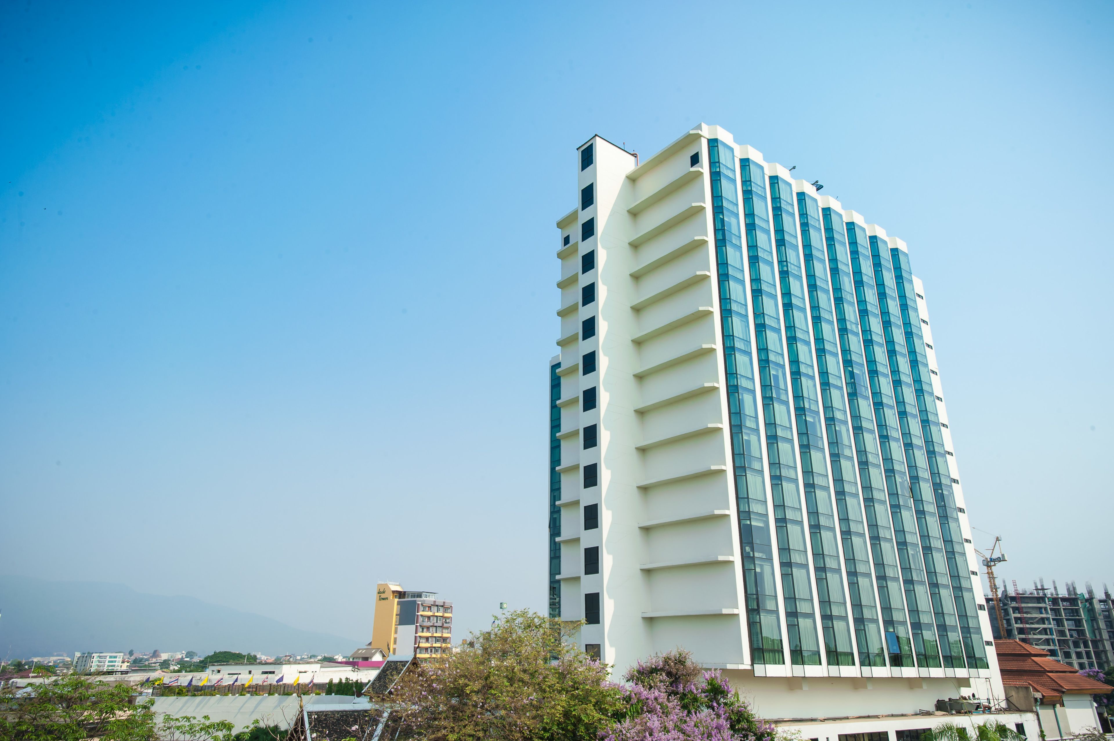 A tall, modern building with a white facade and large windows.